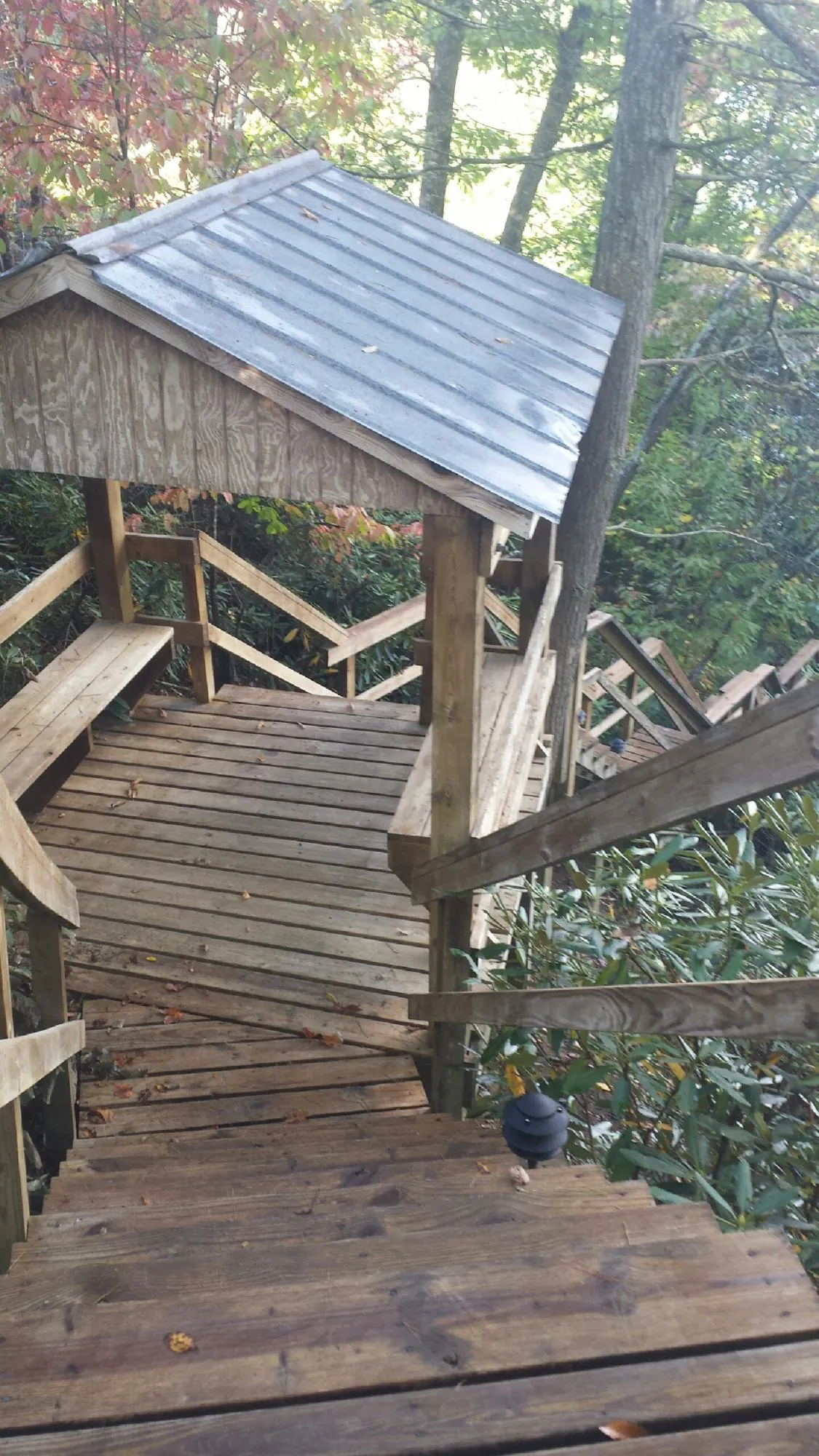 Metal roofed shelter over wooden steps on a wooded walkway — Skylight Repair & Installation work by our crew in Sterling